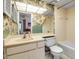 Well-lit bathroom with a vanity, mirror, and floral wallpaper at 3500 El Conquistador Pkwy # 128, Bradenton, FL 34210
