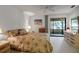 Serene bedroom with a comfortable bed, dresser, and sliding glass doors to a private balcony at 3500 El Conquistador Pkwy # 128, Bradenton, FL 34210