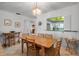 Bright dining room featuring a wood table and chairs, elegant light fixture, and a pass-through to the kitchen at 3500 El Conquistador Pkwy # 128, Bradenton, FL 34210