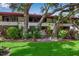 Exterior of the property featuring mature trees and landscaping at 3500 El Conquistador Pkwy # 128, Bradenton, FL 34210