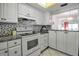 Bright kitchen with mosaic backsplash, granite counters, and white cabinetry, open to the dining area at 3500 El Conquistador Pkwy # 128, Bradenton, FL 34210