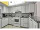 Modern kitchen with white cabinetry, granite countertops, mosaic backsplash, and stainless steel appliances at 3500 El Conquistador Pkwy # 128, Bradenton, FL 34210