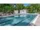 Community pool area with chairs, spa, and lush tropical landscaping at 3500 El Conquistador Pkwy # 128, Bradenton, FL 34210