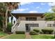 Inviting condo exterior showcases a private courtyard entrance, lush tropical landscaping, and a charming second-story balcony at 3500 El Conquistador Pkwy # 132, Bradenton, FL 34210