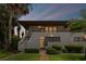 Inviting condo exterior showcases a private courtyard entrance, lush tropical landscaping, and a charming second-story balcony at 3500 El Conquistador Pkwy # 132, Bradenton, FL 34210