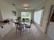 Bright dining area with glass table, neutral decor, and sun-filled windows at 3752 Collins St # 508, Sarasota, FL 34232