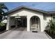 Close-up of the home's entrance with a covered carport, stylish door and trimmed landscaping at 3752 Collins St # 508, Sarasota, FL 34232
