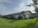 Rear view of a well-kept single-story home featuring manicured lawn and private patio at 3752 Collins St # 508, Sarasota, FL 34232