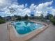 Community pool surrounded by lounge chairs and umbrellas on a sunny day at 3752 Collins St # 508, Sarasota, FL 34232