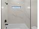 Stylish bathtub and shower featuring sleek black fixtures and bright white marble-look tile at 3865 Everglades Ter, North Port, FL 34286