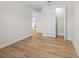 Open bedroom with wood-look tile floors and a view into the kitchen, and a closet with folding doors at 3865 Everglades Ter, North Port, FL 34286