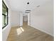 Bedroom with wood-look tile, modern lighting, and an open doorway to the rest of the home at 3865 Everglades Ter, North Port, FL 34286