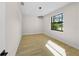Well-lit bedroom boasts wood-look tile floors, a modern light fixture, and a large window overlooking the yard at 3865 Everglades Ter, North Port, FL 34286