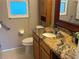 Bathroom featuring a toilet, vanity, and mirror at 390 301 W Blvd # 2C, Bradenton, FL 34205