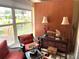 A bright Florida room features comfortable wicker chairs, a glass table, and a view of the outdoors at 390 301 W Blvd # 2C, Bradenton, FL 34205