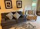 Cozy living room featuring a comfortable gray sofa, patterned accent chair, and stylish decor at 390 301 W Blvd # 2C, Bradenton, FL 34205