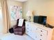 Comfortable bedroom featuring a white dresser, purple recliner, and elegant artwork at 390 301 W Blvd # 2C, Bradenton, FL 34205