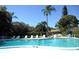 Outdoor pool area features clear blue water, lounge chairs, and table seating under a sunny sky at 390 301 W Blvd # 2C, Bradenton, FL 34205