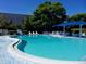 Community pool with ample lounge chairs, umbrellas, and tables for relaxation and socializing at 390 301 W Blvd # 2C, Bradenton, FL 34205