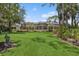 Expansive screened-in backyard with lush green lawn, mature trees, and manicured landscaping at 4224 Boca Pointe Dr, Sarasota, FL 34238