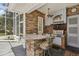 Relaxing screened outdoor kitchen with stone walls and comfortable seating at 4224 Boca Pointe Dr, Sarasota, FL 34238