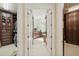 Hallway with walk-in closets leading to the ensuite bathroom with matching wood cabinetry at 4224 Boca Pointe Dr, Sarasota, FL 34238