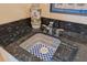 Close up on the wet bar featuring a decorative sink with blue-and-white tiles and stainless steel hardware at 4224 Boca Pointe Dr, Sarasota, FL 34238