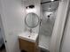 Modern bathroom features a stylish vanity, round mirror, and frameless glass shower with marble tiling at 4460 Emerald Ridge Dr, Sarasota, FL 34233