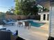 Outdoor pool area with lounge chairs, outdoor seating, grill, and manicured landscaping at 4460 Emerald Ridge Dr, Sarasota, FL 34233