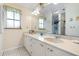 Bathroom with dual sink vanity, large mirror, and natural light, providing a clean and functional space at 4513 Hidden River Rd, Sarasota, FL 34240