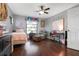 A beautifully decorated bedroom with hardwood floors, ceiling fan, lots of decor, and natural light at 4513 Hidden River Rd, Sarasota, FL 34240