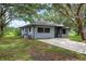 Home featuring a well-kept lawn, mature trees, and a paved driveway at 4513 Hidden River Rd, Sarasota, FL 34240