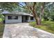 Charming single-story home with mature trees and a concrete driveway at 4513 Hidden River Rd, Sarasota, FL 34240