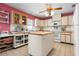 Bright kitchen featuring an island, neutral cabinetry, tile flooring, and modern appliances at 4513 Hidden River Rd, Sarasota, FL 34240