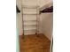 Walk-in closet with adjustable metal shelving and wood-look flooring at 4520 47Th W Ave # 103, Bradenton, FL 34210