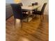 Dining table with dark chairs and modern wood laminate flooring at 4520 47Th W Ave # 103, Bradenton, FL 34210