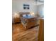 Well-lit main bedroom with lamps, painting, and hardwood floors at 4520 47Th W Ave # 103, Bradenton, FL 34210