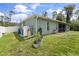 Backyard featuring utilities, a garden bed, and the home's exterior with a screened-in patio at 4565 Eldron Ave, North Port, FL 34286