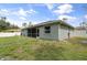 Exterior shot featuring a screened-in patio, lush lawn, and the side of the house at 4565 Eldron Ave, North Port, FL 34286