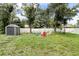 Private backyard with a storage shed, a firepit with Adirondack chairs, and white fence at 4565 Eldron Ave, North Port, FL 34286