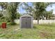 Backyard showing storage shed with gray siding and black hardware near fence at 4565 Eldron Ave, North Port, FL 34286