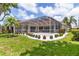 Backyard featuring a screened-in patio, lush landscaping and lawn at 4958 Gardiners Bay Cir, Sarasota, FL 34238