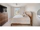 Bedroom showcasing natural light from the window, wooden bed frame and a dresser with television at 525 N Orange Ave # 302, Sarasota, FL 34236