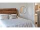 Bright bedroom with a decorative round mirror, a light-colored bed, and a glimpse into the en suite bathroom at 525 N Orange Ave # 302, Sarasota, FL 34236
