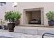 Outdoor fireplace with planters, on a patio of brick pavers, with neutral colored walls at 525 N Orange Ave # 302, Sarasota, FL 34236