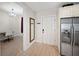 Hallway featuring wood floors, a mirror, a view of a bedroom and stainless steel refrigerator at 525 N Orange Ave # 302, Sarasota, FL 34236