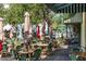 Outdoor dining area with tables, umbrellas and green wicker chairs at 525 N Orange Ave # 302, Sarasota, FL 34236
