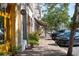 Street view showing a line of parked cars in front of various storefronts and greenery at 525 N Orange Ave # 302, Sarasota, FL 34236