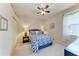 Cozy bedroom showcasing natural light from a window, complemented by a comfortable queen bed and stylish nautical decor at 5359 90Th Avenue E Cir, Parrish, FL 34219