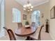 Elegant dining room with an oval wood table, chandelier, and arched windows bringing in natural light at 5359 90Th Avenue E Cir, Parrish, FL 34219